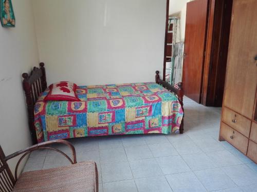 a bedroom with a bed with a colorful quilt at Maison Au pied du Volcan in Curepipe