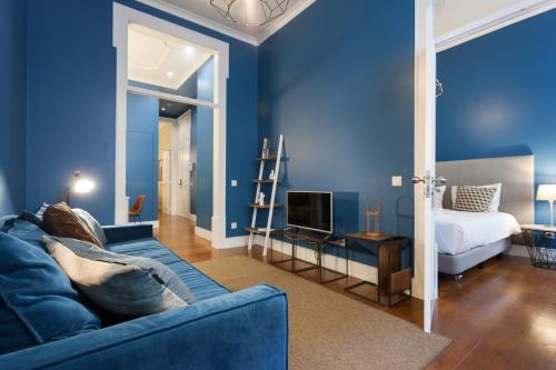 ein blaues Wohnzimmer mit einem Sofa und einem Bett in der Unterkunft Baixa Vintage Three-Bedroom Apartment - by LU Holidays in Lissabon