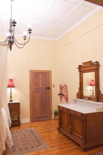 a room with a bath tub and a mirror at Lockerbie Lodge in Vryburg
