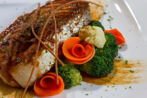 a plate with a piece of meat and broccoli at New York Hotel in Phnom Penh