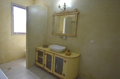 a bathroom with a sink and a mirror on the wall at Bianca Suite & Home in Psinthos