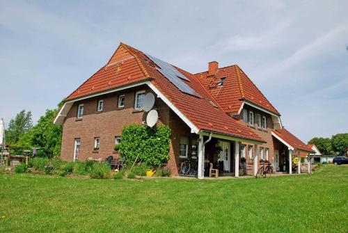 Lancken-GranitzにあるFerienwohnungen zum Neuensiener See Pの赤い屋根の大きなレンガ造りの家