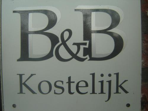 a white sign with the words kosticism on it at B & B Kostelijk in Boekelo