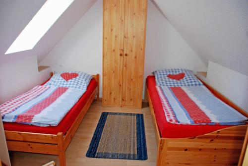 2 Betten in einem Zimmer mit Dachgeschoss in der Unterkunft Ferienhaus in Lauterbach mit Kachelofen in Lauterbach