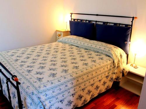 een slaapkamer met een bed met een blauwe en witte sprei bij Spacious Holiday Home with Private Garden and Barbecue in Lazise