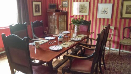 een eetkamer met een houten tafel en stoelen bij Orchard Pond Bed & Breakfast in Duxford