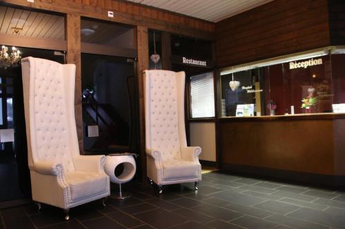 two chairs sitting next to a bar in a restaurant at Minster Hotel in Unteriberg