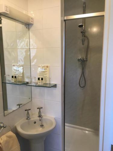 a bathroom with a shower and a sink and a toilet at Yarn Market Hotel in Dunster