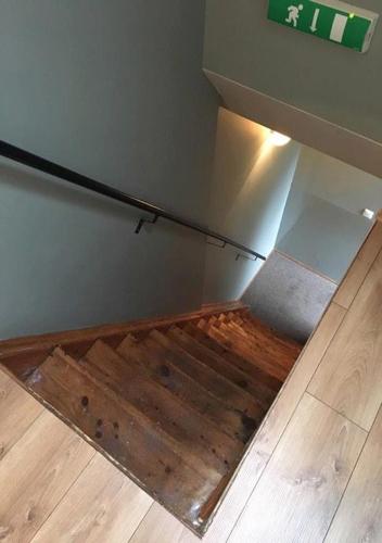 a stairwell with a wooden floor and a wall with aiction at Old Charm Reykjavik Apartments in Reykjavík
