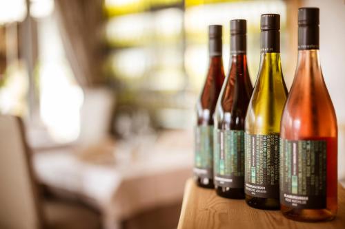 four bottles of wine sitting on a wooden table at Hotel Weingut Innerleiterhof in Schenna