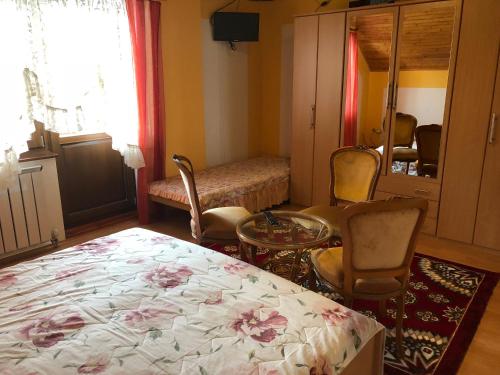 a bedroom with a bed and chairs and a window at Adele Rooms Nova Lesna in Nová Lesná