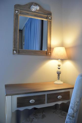 a desk with a lamp and a mirror on a wall at Villa Aggemari in Apidias Lakos