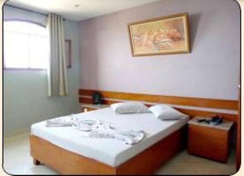 1 dormitorio con 1 cama y una foto en la pared en Estalagem Motel (Adult Only), en Río de Janeiro