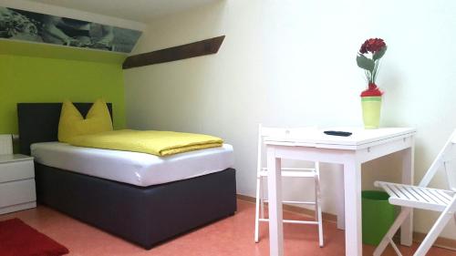 a small bedroom with a bed and a table at Radlerhof Spreewald in Kolkwitz