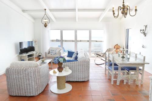 ein Wohnzimmer mit Sofas und ein Esszimmer in der Unterkunft Casa na Areia in Lavos