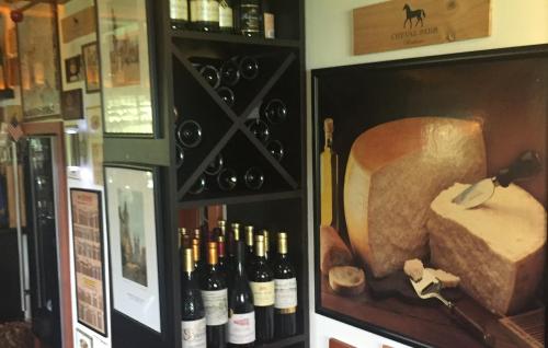 a display case with bottles of wine and a cheese at Villa Rozmaryn & Gourmet in Mariánské Lázně