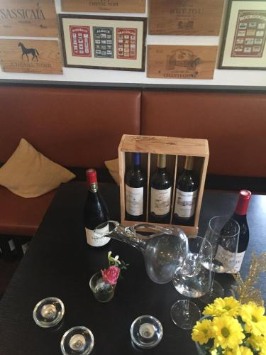a table with bottles of wine and glasses on it at Villa Rozmaryn & Gourmet in Mariánské Lázně