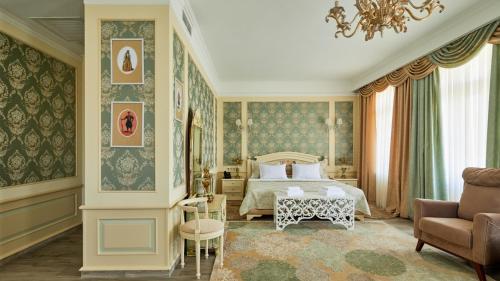 a bedroom with a bed and a couch and a chair at Hotel Aivani Old Tbilisi in Tbilisi City