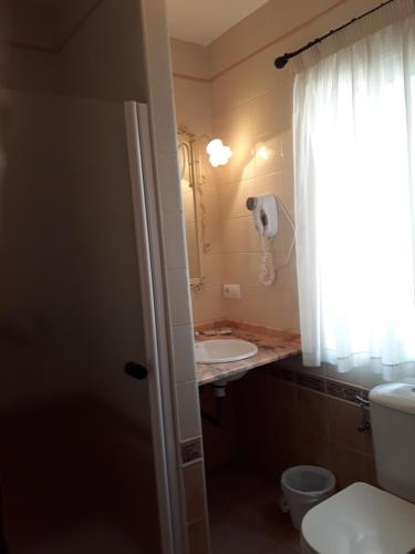 a bathroom with a toilet and a sink at Pension Doña Trinidad in Seville