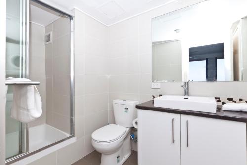 a bathroom with a toilet and a sink and a shower at Surf Regency in Gold Coast