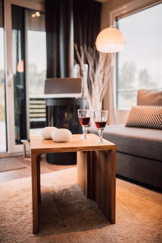 two glasses of wine on a coffee table in a living room at Goitzsche Resort in Bitterfeld