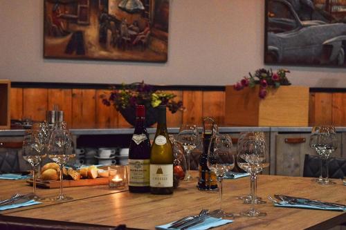 a table with bottles of wine and glasses on it at De Borgh in Zevenbergen