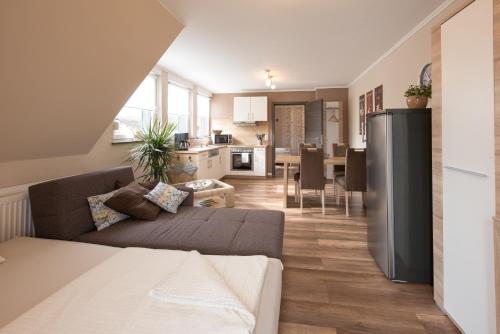 ein Wohnzimmer mit einem Sofa und einer Küche in der Unterkunft Gästehaus Eifelzauber in Kelberg