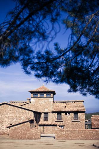 a large brick building with a tile roof at Hotel Restaurante Masía la Torre in Mora de Rubielos