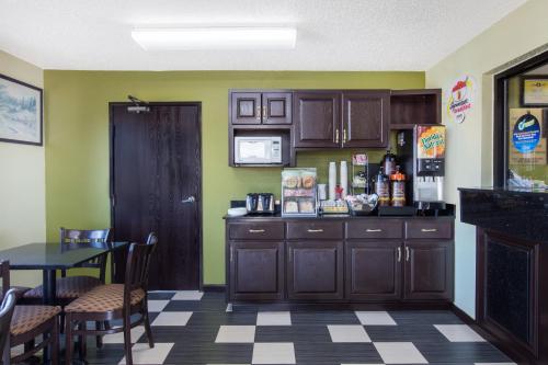 a kitchen with wooden cabinets and a table in a room at Super 8 by Wyndham Aberdeen MD in Aberdeen