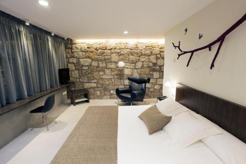 a bedroom with a bed and a stone wall at Hotel Restaurante Masía la Torre in Mora de Rubielos