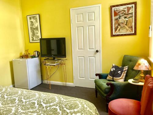 a room with a bed and a tv and a door at Vine Valley Inn in Cessnock