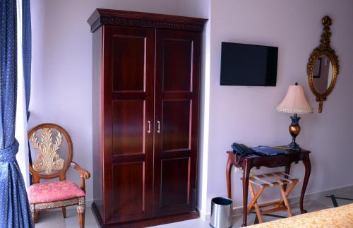 a wooden cabinet in a bedroom with a table and a lamp at Arbia Dorka Heritage Palace in Varaždin