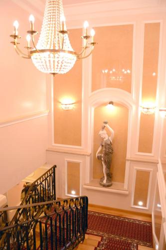 a statue of a woman in a room with a chandelier at Arbia Dorka Heritage Palace in Varaždin