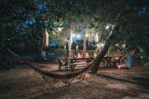 a hammock hanging from a tree in a park at night at Alegria Villas Complex in Vasilikos