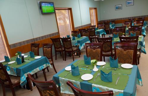 a dining room with blue tables and chairs at Hotel Gopalapuram International in Pollāchi