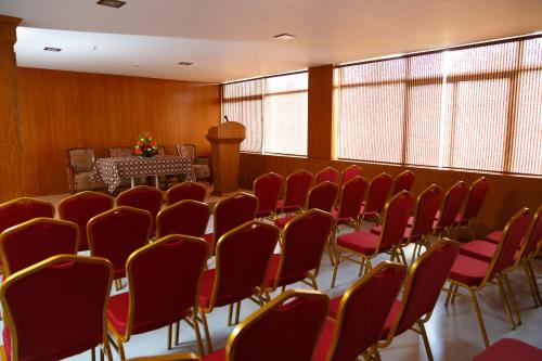 a conference room with red chairs and a table at Hotel Gopalapuram International in Pollāchi
