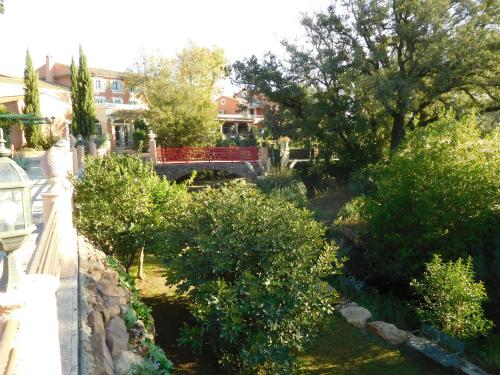 a view of a garden with trees and a red bench at Le Mas du Lingousto in Cuers