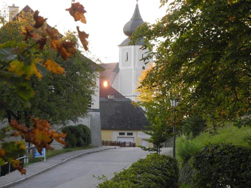 a church with a white building with a steeple at Ferienwohnungen Kössl in Waidhofen an der Ybbs