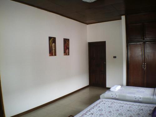 a bedroom with two beds and two pictures on the wall at Lavender Lodge Hotel in Accra
