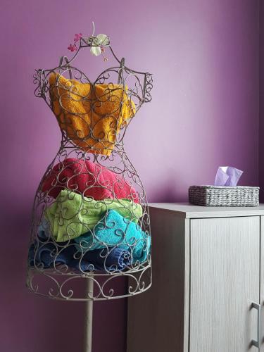 a colorful glass vase on a stand next to a table at B&B Au Jardin Fleuri in Marche-en-Famenne