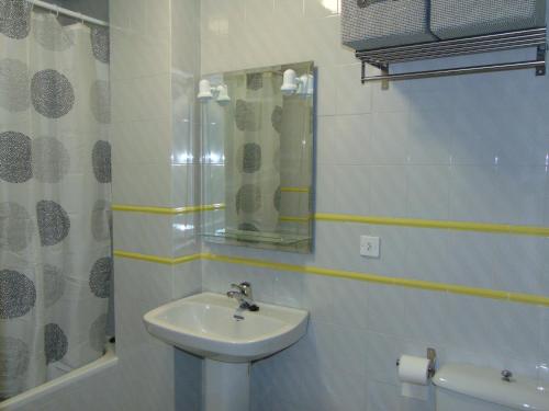 y baño blanco con lavabo y ducha. en Vivienda Turistica Bufer, en Úbeda