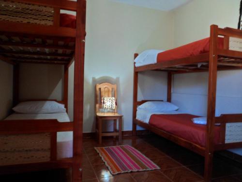 Habitación con 3 literas y espejo. en El Cardon Hospedaje en Huacalera