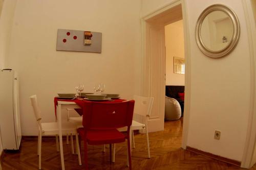 un tavolo da pranzo con sedie rosse e uno specchio di Bridge apartment a Belgrado