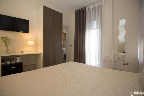 a white bedroom with a bed and a window at SalernoPrestige rooms in Salerno