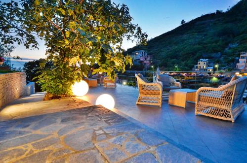 a patio with chairs and a tree and lights at Cinqueterre Residence in Riomaggiore