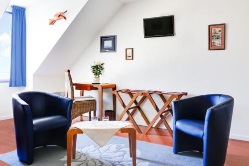 ein Wohnzimmer mit 2 Stühlen und einem Tisch in der Unterkunft Hôtel Le Chevalier Gambette in Saint-Armel