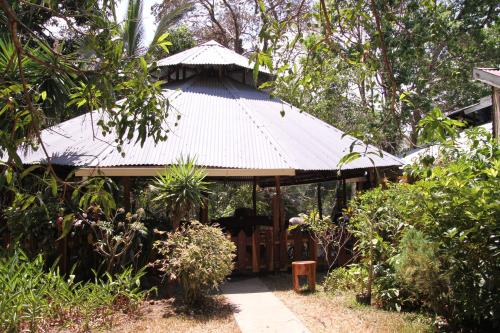 a building with a tin roof in a garden at Cabañas Cañas Castilla in La Cruz