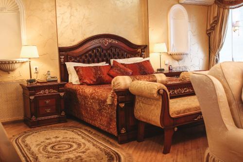 ein Schlafzimmer mit einem großen Bett und einem Stuhl in der Unterkunft Gloria Business Hotel in Blagoweschtschensk