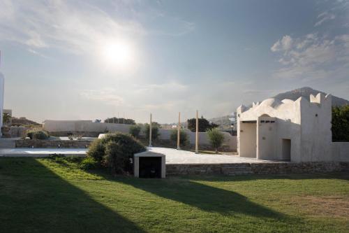 a white building with the sun in the sky at Naxos Euphoria Suites in Stelida