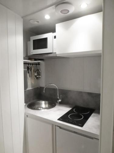 une petite cuisine avec un évier et un micro-ondes dans l'établissement L'IDEAL 6 ( casino a 50m, plage a 150m), à Trouville-sur-Mer